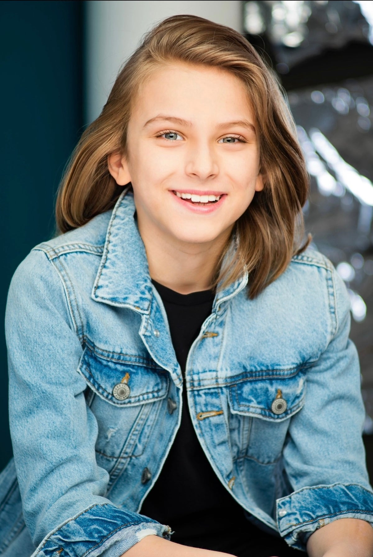 Max wearing a denim jacket with a blurred background